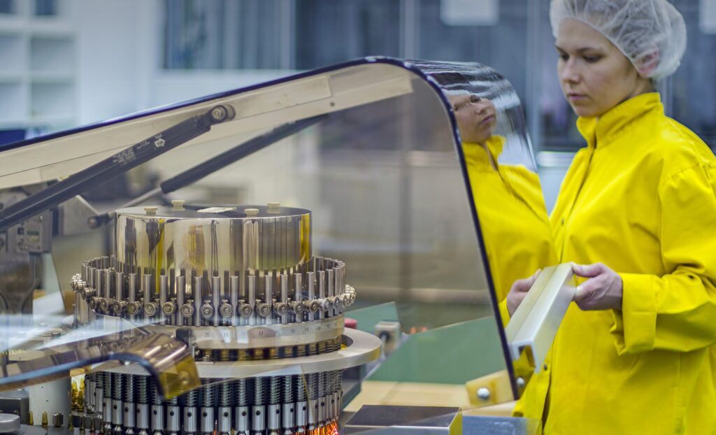 A professional worker with yellow lab coat working in a lab.