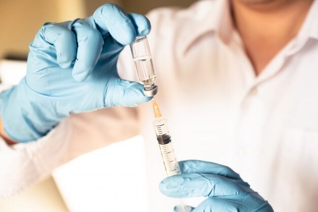Doctor nurse holding flu measles vaccine vial syringe baby vaccination medicine drug concept